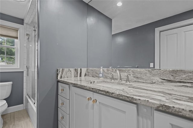 1221 Phenix Ave, Cranston, RI 02921 - full bath with toilet, vanity, bath / shower combo with glass door, and baseboards