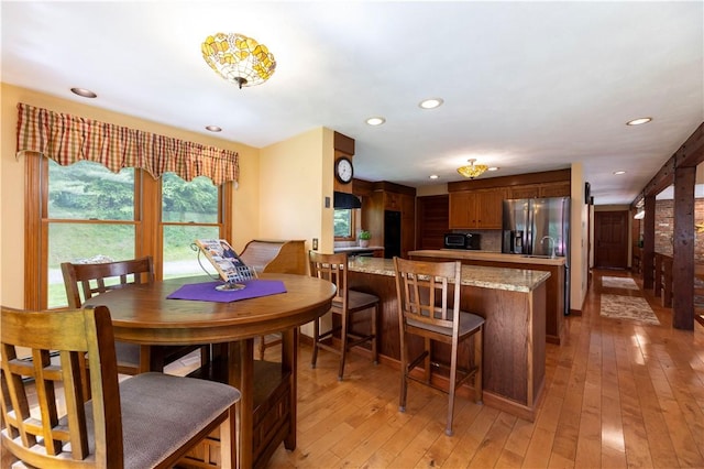 71 Phillips Ln, Glocester, RI 02814 - kitchen with stainless steel refrigerator with ice dispenser, light wood-style floors, recessed lighting, a peninsula, and light stone counters