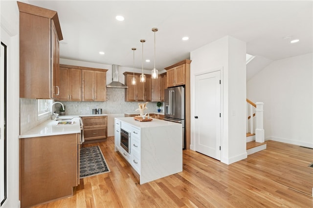 51 Burnett Rd, Warwick, RI 02889 - kitchen with high quality fridge, wall chimney exhaust hood, a sink, light wood-style flooring, and a kitchen island