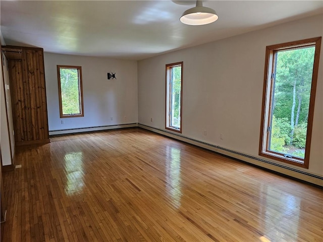 66 Shadbush Rd, South Kingstown, RI 02879 - empty room featuring plenty of natural light, light wood finished floors, a baseboard heating unit, and baseboards