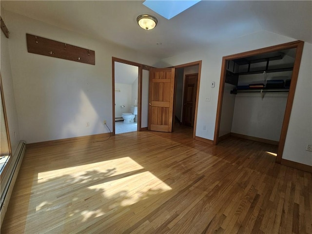 66 Shadbush Rd, South Kingstown, RI 02879 - unfurnished bedroom with a skylight, wood finished floors, a baseboard heating unit, a closet, and baseboards