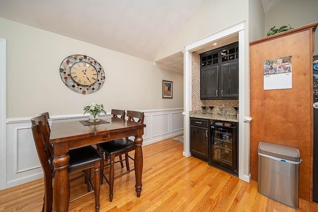 1421 Douglas Ave Unit E, North Providence, RI 02904 - dining space with a decorative wall, light wood-style flooring, a wainscoted wall, wine cooler, and lofted ceiling