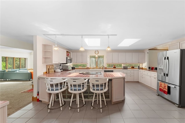 336 Switch Rd, Richmond, RI 02832 - kitchen featuring stainless steel appliances, a skylight, light countertops, a peninsula, and rail lighting