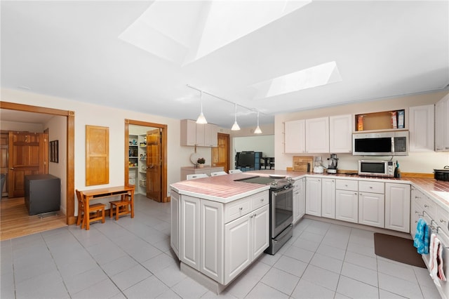 336 Switch Rd, Richmond, RI 02832 - kitchen with stainless steel appliances, a skylight, rail lighting, light countertops, and light tile patterned flooring