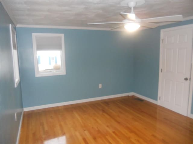 20 Anchorage Rd, Narragansett, RI 02882 - empty room with a ceiling fan, wood finished floors, baseboards, and ornamental molding