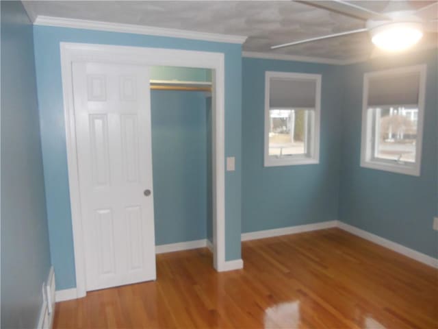 20 Anchorage Rd, Narragansett, RI 02882 - unfurnished bedroom featuring wood finished floors, crown molding, baseboards, and a closet