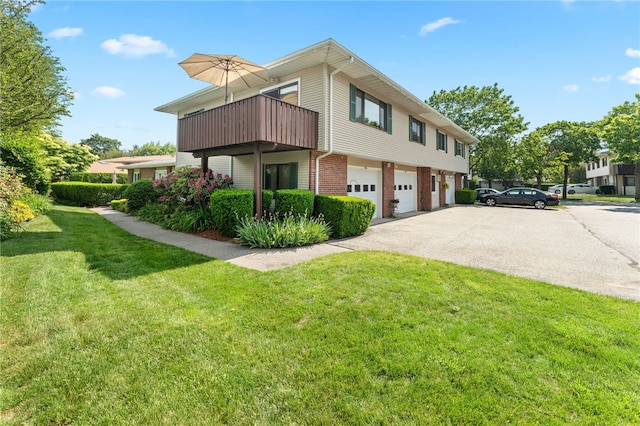 694 Orleans Ct, Warwick, RI 02886 - view of side of home featuring a garage, brick siding, a yard, driveway, and a balcony