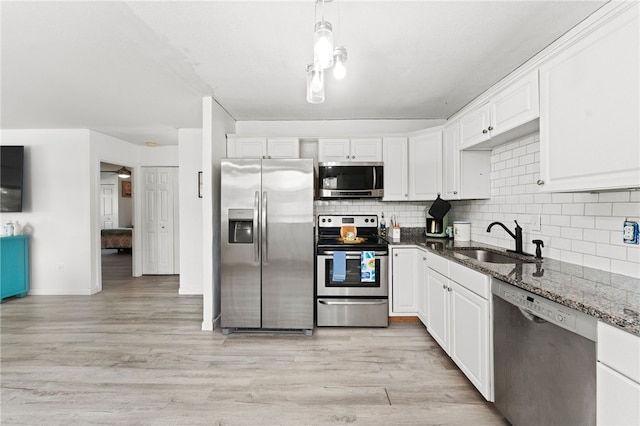 694 Orleans Ct, Warwick, RI 02886 - kitchen featuring appliances with stainless steel finishes, a sink, dark stone counters, white cabinets, and tasteful backsplash