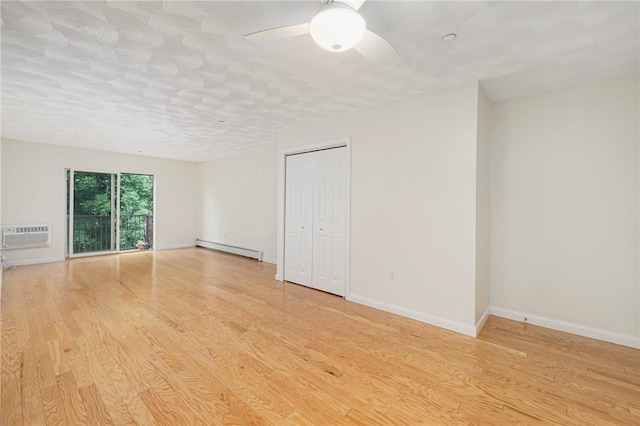 752 Quaker Ln Unit C311, Warwick, RI 02818 - empty room with a baseboard radiator, light wood finished floors, a wall mounted AC, and a ceiling fan