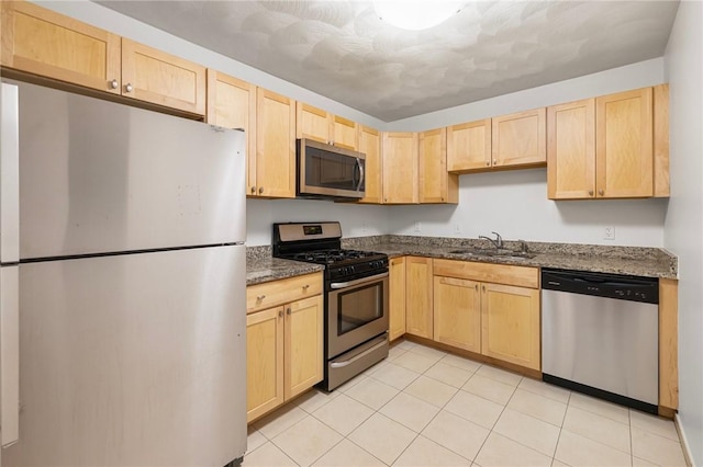 752 Quaker Ln Unit C311, Warwick, RI 02818 - kitchen with appliances with stainless steel finishes, light brown cabinetry, dark stone counters, and light tile patterned flooring