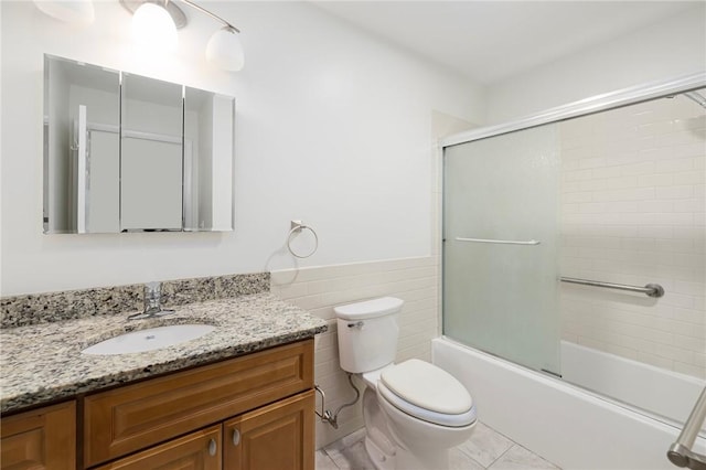 752 Quaker Ln Unit C311, Warwick, RI 02818 - full bath featuring vanity, shower / bath combination with glass door, a wainscoted wall, and tile walls