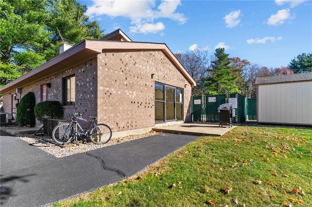 752 Quaker Ln Unit C311, Warwick, RI 02818 - back of house with brick siding, a gate, and an outdoor structure