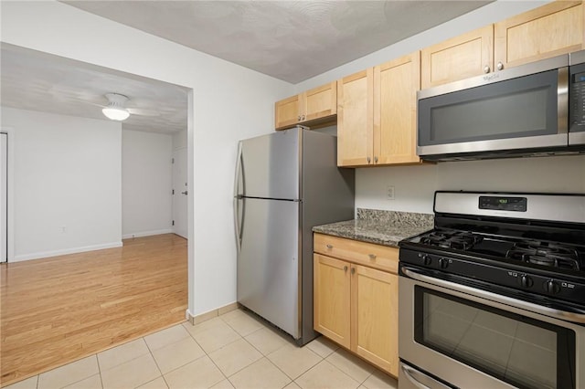 752 Quaker Ln Unit C311, Warwick, RI 02818 - kitchen featuring stainless steel appliances, light brown cabinets, dark stone counters, light tile patterned flooring, and ceiling fan