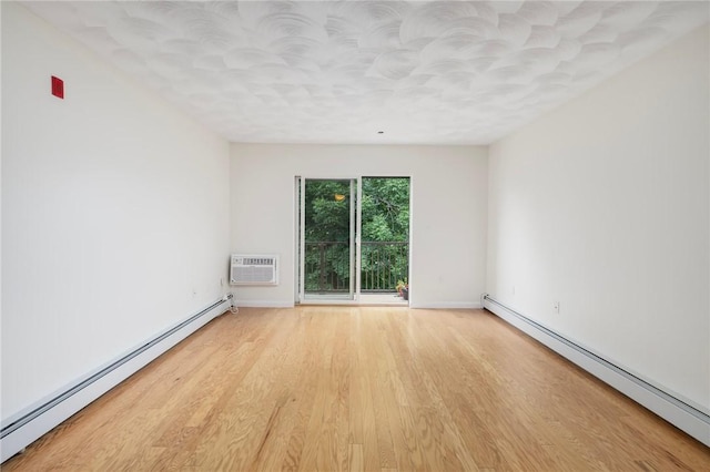 752 Quaker Ln Unit C311, Warwick, RI 02818 - spare room featuring a baseboard radiator, a wall mounted AC, light wood-type flooring, and a textured ceiling