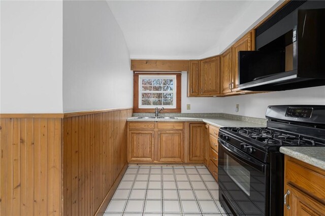 52 Pleasant View Rd, Warwick, RI 02888 - kitchen featuring black gas range, a sink, a wainscoted wall, light countertops, and brown cabinets