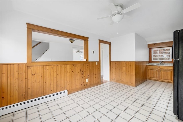 52 Pleasant View Rd, Warwick, RI 02888 - spare room featuring wainscoting, a baseboard heating unit, wooden walls, ceiling fan, and a sink