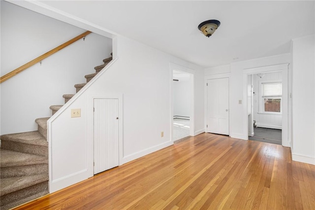 52 Pleasant View Rd, Warwick, RI 02888 - unfurnished living room featuring stairs, light wood-type flooring, a baseboard heating unit, and baseboards