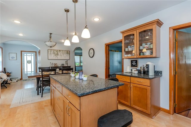 2 Ann St, North Providence, RI 02904 - kitchen featuring arched walkways, a kitchen island, light wood finished floors, glass insert cabinets, and recessed lighting