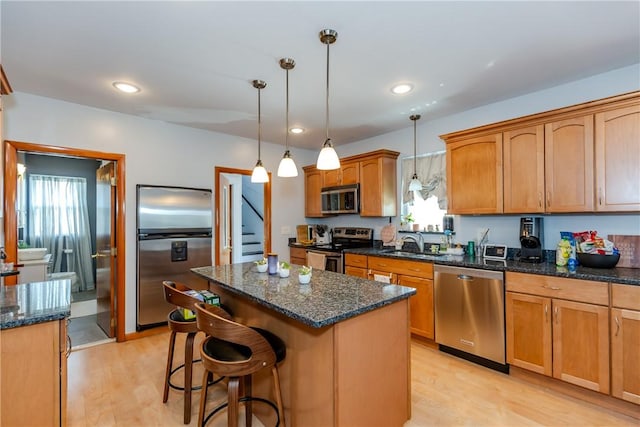 2 Ann St, North Providence, RI 02904 - kitchen with stainless steel appliances, a sink, a kitchen island, light wood-style floors, and hanging light fixtures