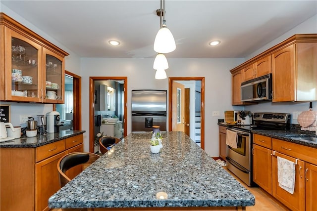 2 Ann St, North Providence, RI 02904 - kitchen featuring stainless steel appliances, glass insert cabinets, dark stone counters, hanging light fixtures, and recessed lighting