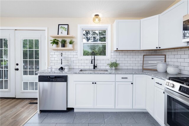 259 Buttonwoods Ave, Warwick, RI 02886 - kitchen with appliances with stainless steel finishes, a sink, open shelves, light stone countertops, and white cabinets