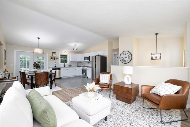 259 Buttonwoods Ave, Warwick, RI 02886 - living area featuring wood finished floors, vaulted ceiling, and a chandelier