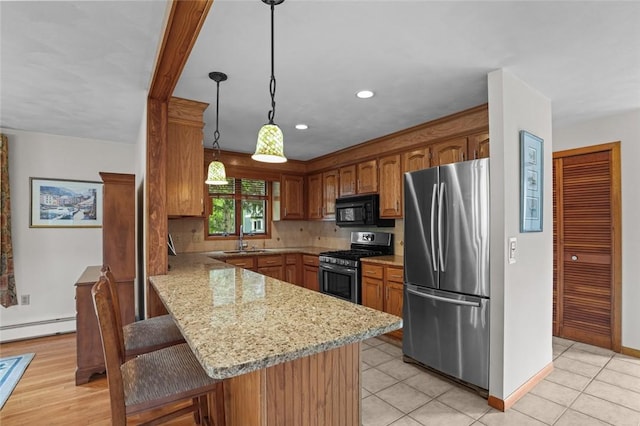 236 Indian Trl, Narragansett, RI 02874 - kitchen with stainless steel appliances, a baseboard radiator, a sink, a breakfast bar area, and a peninsula