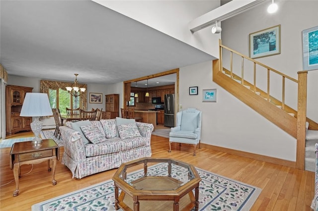 236 Indian Trl, Narragansett, RI 02874 - living area featuring light wood-style floors, a chandelier, stairs, baseboards, and track lighting