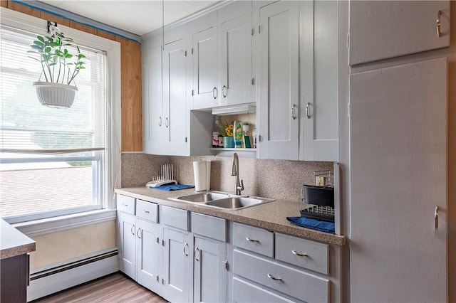 263 Front St, Lincoln, RI 02865 - kitchen featuring a sink, a baseboard heating unit, healthy amount of natural light, and tasteful backsplash