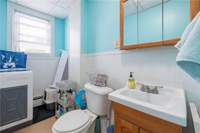 263 Front St, Lincoln, RI 02865 - bathroom featuring baseboard heating, vanity, toilet, a drop ceiling, and tile walls