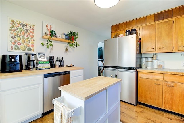 80 Barrett Ave, North Providence, RI 02904 - kitchen featuring appliances with stainless steel finishes, open shelves, arched walkways, light wood-type flooring, and a kitchen island