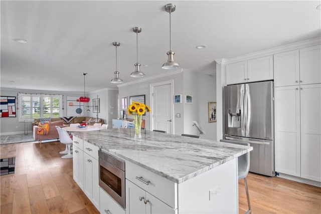 40 Kettle Point Ave, East Providence, RI 02914 - kitchen featuring appliances with stainless steel finishes, open floor plan, crown molding, a breakfast bar, and a kitchen island