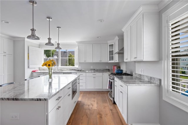40 Kettle Point Ave, East Providence, RI 02914 - kitchen with appliances with stainless steel finishes, a kitchen island, light wood finished floors, white cabinetry, and light stone counters
