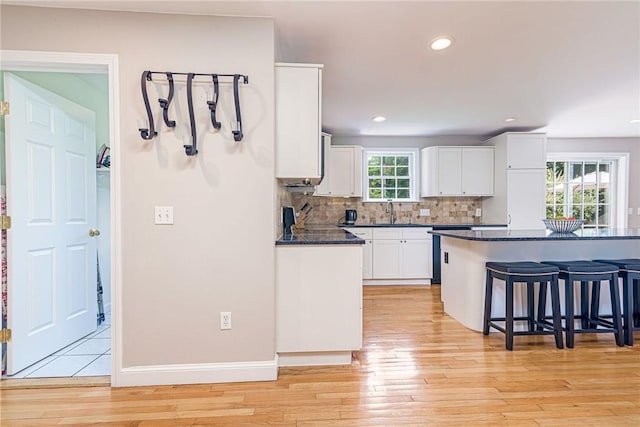 59 Intrepid Ln, Jamestown, RI 02835 - kitchen with a kitchen breakfast bar, light wood-type flooring, a sink, white cabinets, and recessed lighting