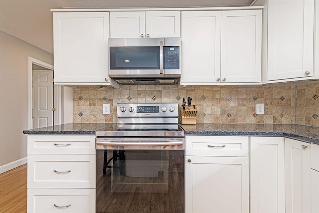 59 Intrepid Ln, Jamestown, RI 02835 - kitchen with appliances with stainless steel finishes, white cabinets, dark stone counters, and tasteful backsplash
