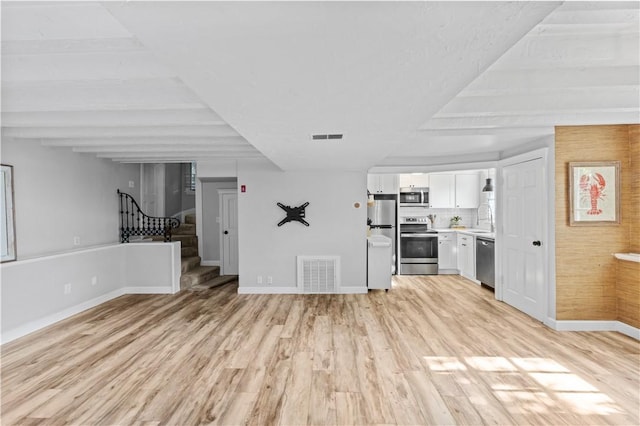 694 Windwood Dr Unit C, Tiverton, RI 02878 - unfurnished living room with a sink, baseboards, light wood-style floors, and stairs