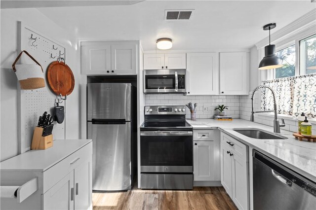 694 Windwood Dr Unit C, Tiverton, RI 02878 - kitchen featuring appliances with stainless steel finishes, a sink, white cabinetry, tasteful backsplash, and light wood-style floors