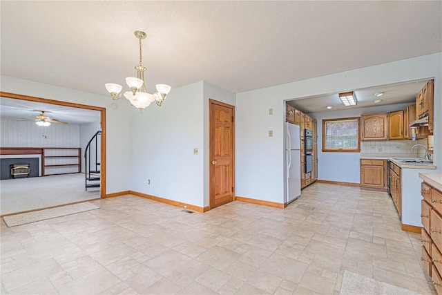 10 Joanth Ter, Westerly, RI 02891 - kitchen featuring a sink, light countertops, a fireplace, a ceiling fan, and a chandelier