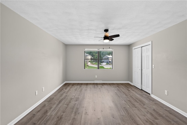 403 Pinewood Dr, Smithfield, RI 02917 - unfurnished bedroom with wood finished floors, baseboards, a textured ceiling, and a closet