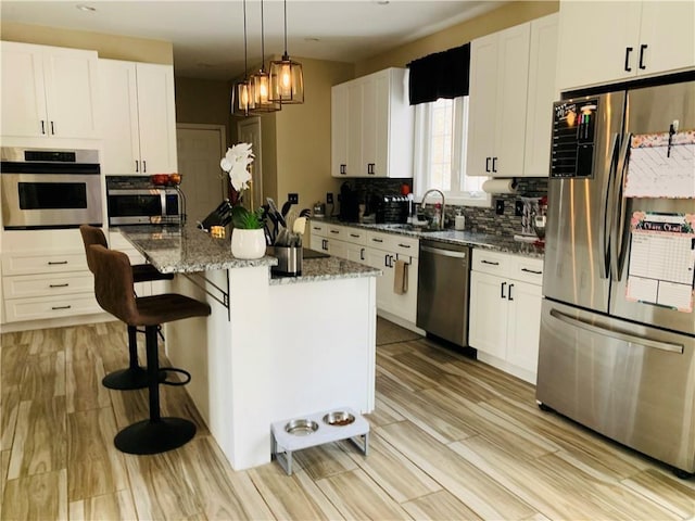 20 Canton Ct, Cranston, RI 02921 - kitchen featuring appliances with stainless steel finishes, a sink, white cabinets, light stone counters, and tasteful backsplash