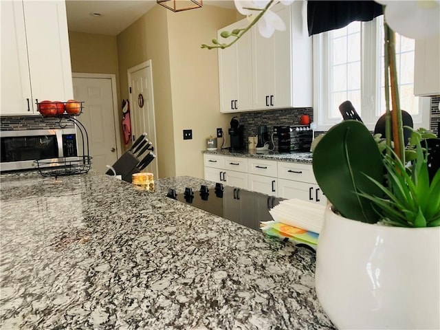 20 Canton Ct, Cranston, RI 02921 - kitchen with stainless steel microwave, decorative backsplash, white cabinets, and light stone countertops