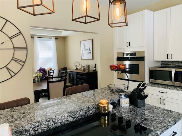 20 Canton Ct, Cranston, RI 02921 - kitchen with appliances with stainless steel finishes, dark stone countertops, white cabinetry, and pendant lighting