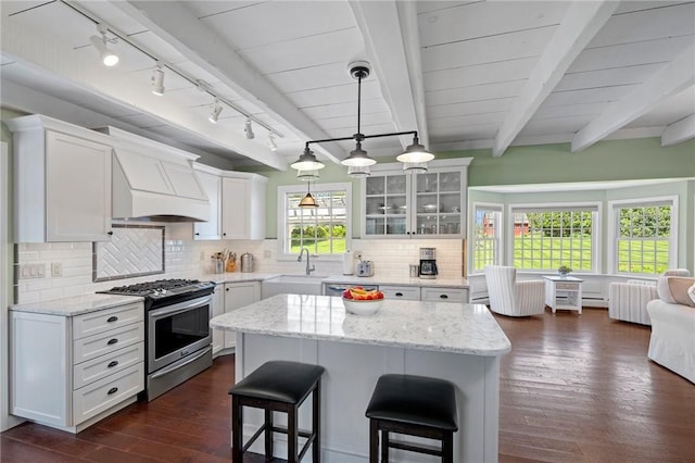 31 Peaceful Way, Tiverton, RI 02878 - kitchen featuring stainless steel range with gas stovetop, track lighting, a breakfast bar, dark wood-type flooring, and white cabinetry