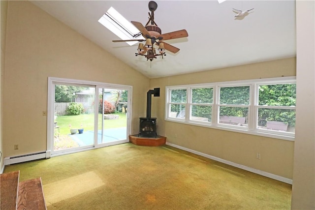 23 Sherman Ln, Middletown, RI 02842 - carpeted empty room featuring a wood stove, a baseboard heating unit, lofted ceiling, a ceiling fan, and a skylight