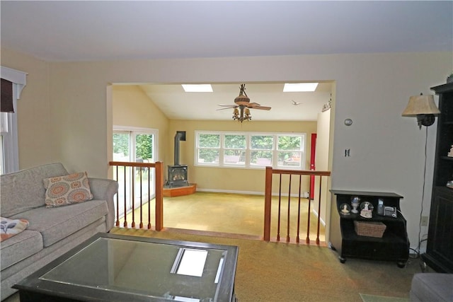 23 Sherman Ln, Middletown, RI 02842 - carpeted living room featuring ceiling fan, a skylight, a wood stove, and vaulted ceiling