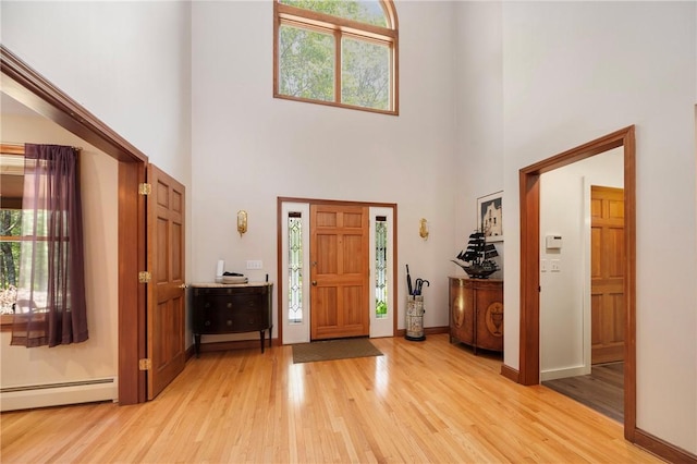 350 Austin Farm Rd, Exeter, RI 02822 - entryway featuring a baseboard radiator, a high ceiling, light wood finished floors, and baseboards