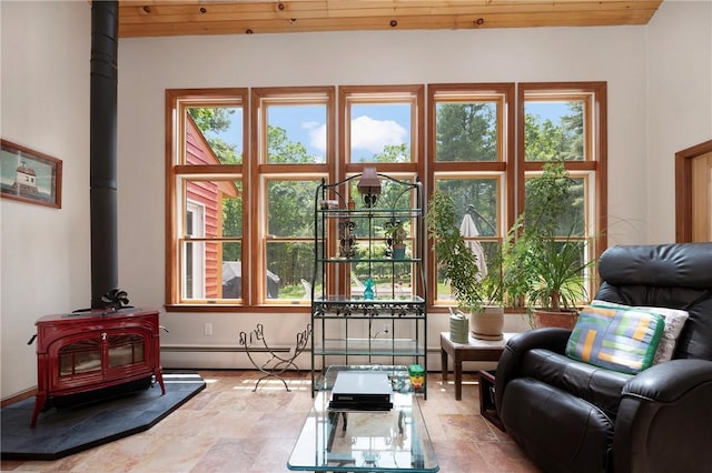 350 Austin Farm Rd, Exeter, RI 02822 - living area featuring a wood stove, stone finish floors, plenty of natural light, wooden ceiling, and baseboard heating