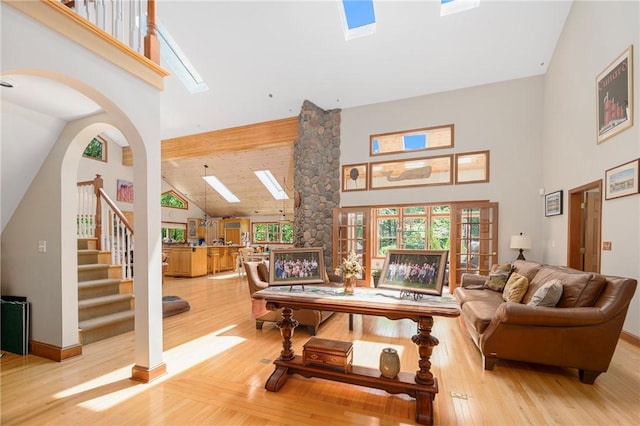 350 Austin Farm Rd, Exeter, RI 02822 - living area featuring a skylight, high vaulted ceiling, wood finished floors, stairway, and baseboards