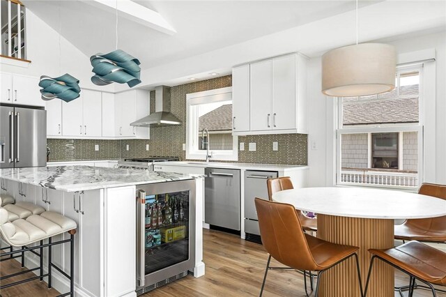 413 Atlantic Ave, Westerly, RI 02891 - kitchen featuring wall chimney exhaust hood, a center island, appliances with stainless steel finishes, wine cooler, and tasteful backsplash