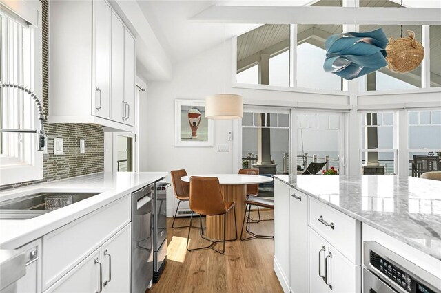 413 Atlantic Ave, Westerly, RI 02891 - kitchen featuring decorative backsplash, light wood finished floors, oven, white cabinets, and a sink